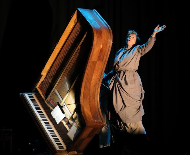 a woman with a grand piano on it's side