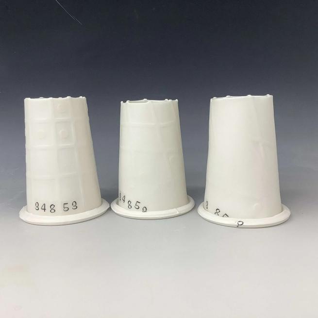 A series of three white ceramic forms based on dye cones