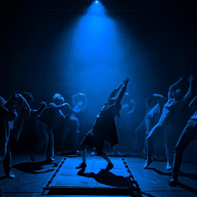 Group of dancers in blue lighting 