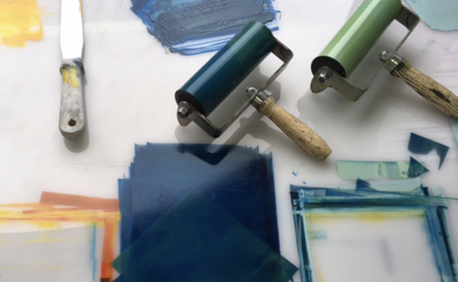 Image shows some inks rolled out onto a surface with some rollers and a palette knife
