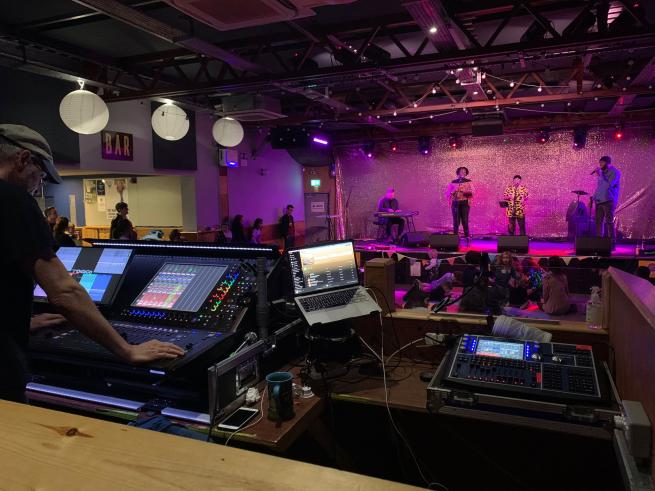 Image showing the sound decks, audience and a band performing at a Made with Music mini-gig