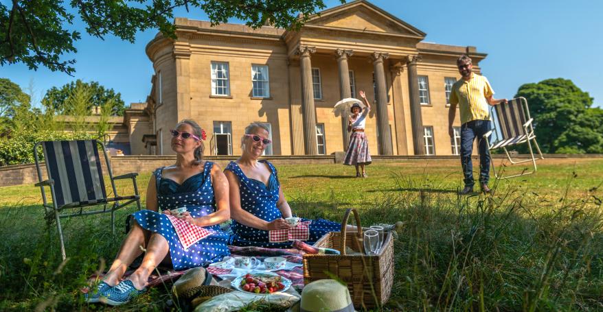 People having a picnic on the grass outside the Mansion at Roundhay Park