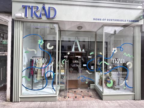 Image of Trad Collectives store front, Text visable on window 1 reads: Sustainable, Vintage, Preloved, local. window 2: shop & studio Mendings and alterations Made to order
