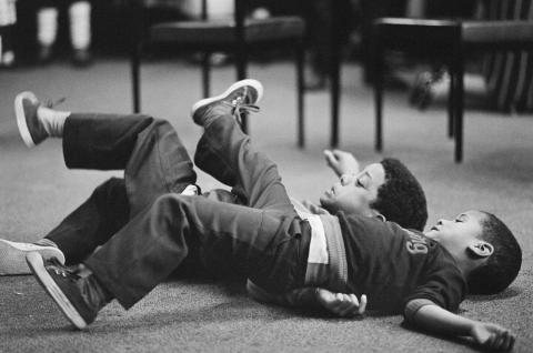 Two boys tussling at the Leeds West Indian Centre. Apr 1983. © Historic England Archive.