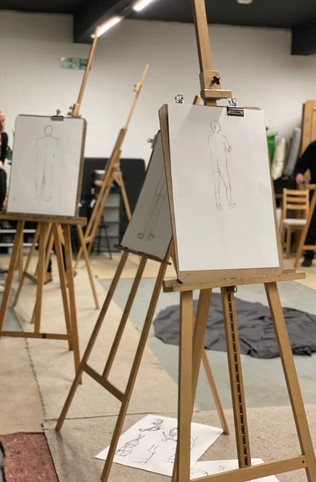 An art studio with easels showing drawings of a life model