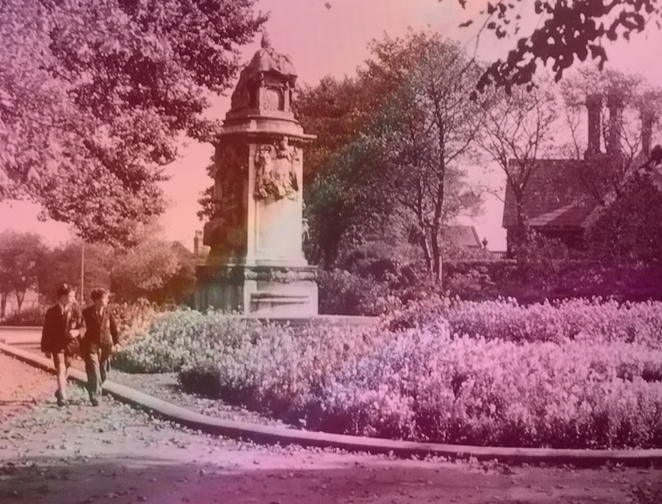 An old fashioned photograph of Woodhouse Moor showing the Queer Victoria statue and a flowerbed