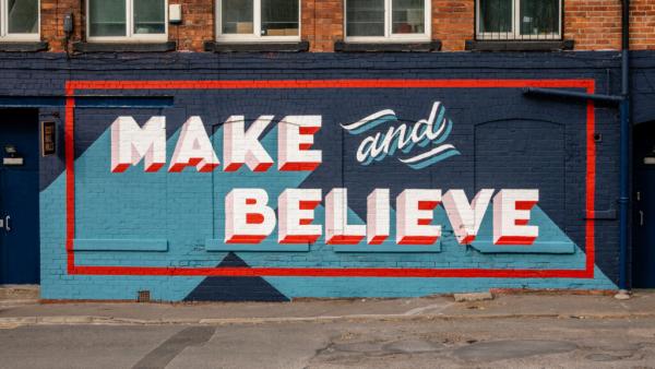 a mural in blue and red stating 'Make and Believe'