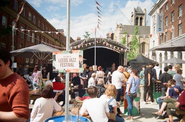 an outdoor scene of people listening to music played on a stage