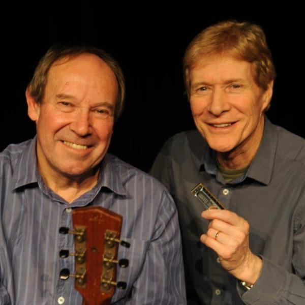 Paul Jones & Dave Kelly holding an acoustic guitar and a harmonica.