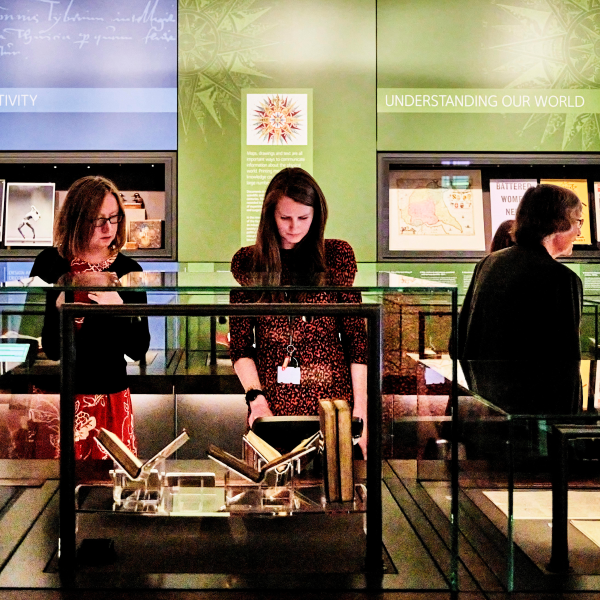 People looking at objects in glass cases in the Treasures of the Brotherton