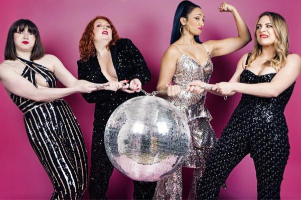 Katy Baker, Issy Wroe Wright, Charlotte Brooke and Arabella Rodrigo play tug of war with a glitter ball against a pink background.