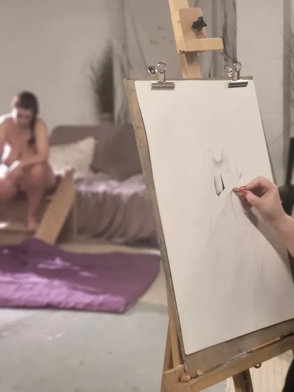 A point of view of an artist at an easel, with the life model in background