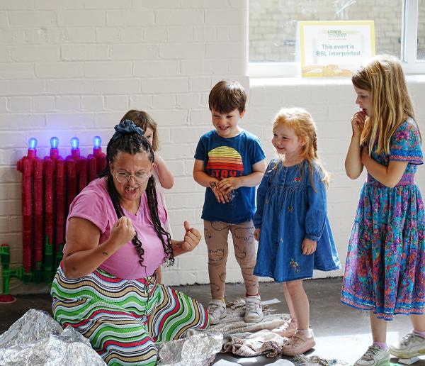 Children listening to someone telling a story. They are smiling.