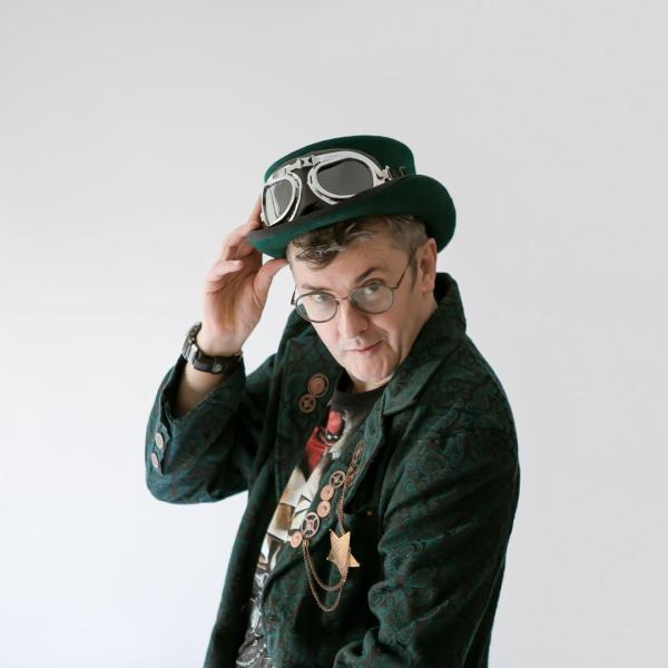 Joe Pasquale in steam punk attire looking straight at the camera.