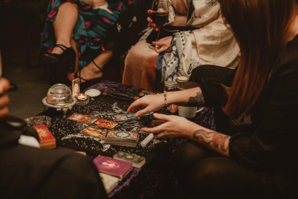 A group sat around a deck of tarot cards