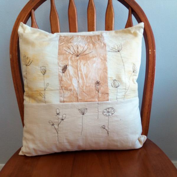 A cushion featuring free machine embroidery designs