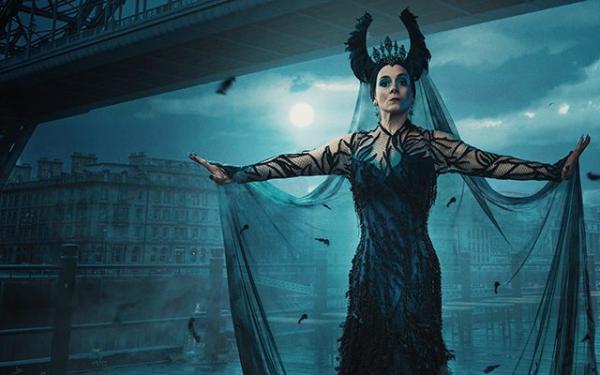 A woman with horns stood in front of a bridge.