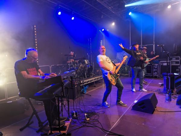 Paul Winn of DC Blues hailing the keys player while Ben Darwin is arched with his bass guitar