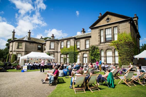 People watching a band outside Lotherton Hall Estate. 