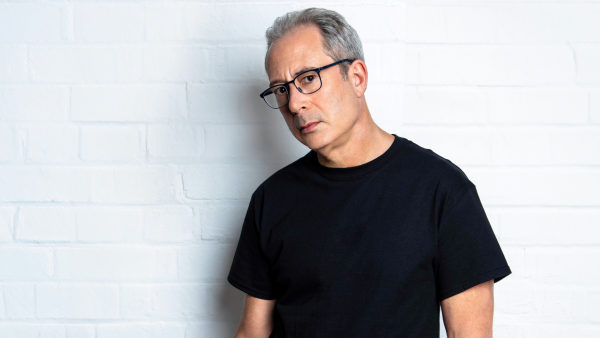 A person wearing a black t-shirt and glasses.