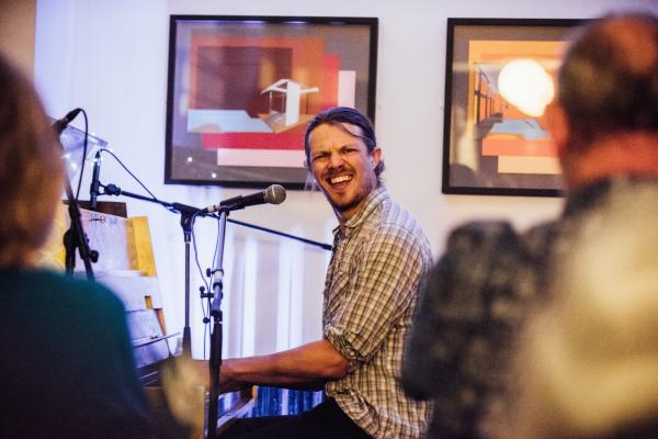 A white man playing the piano in a pub