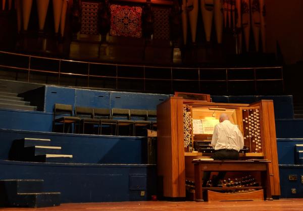 A musician sat playing the organ.