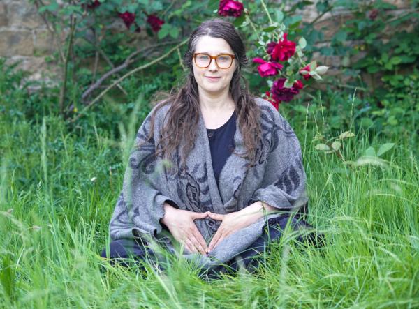 Sophie, the workshop facilitator, sitting in a field with flowers