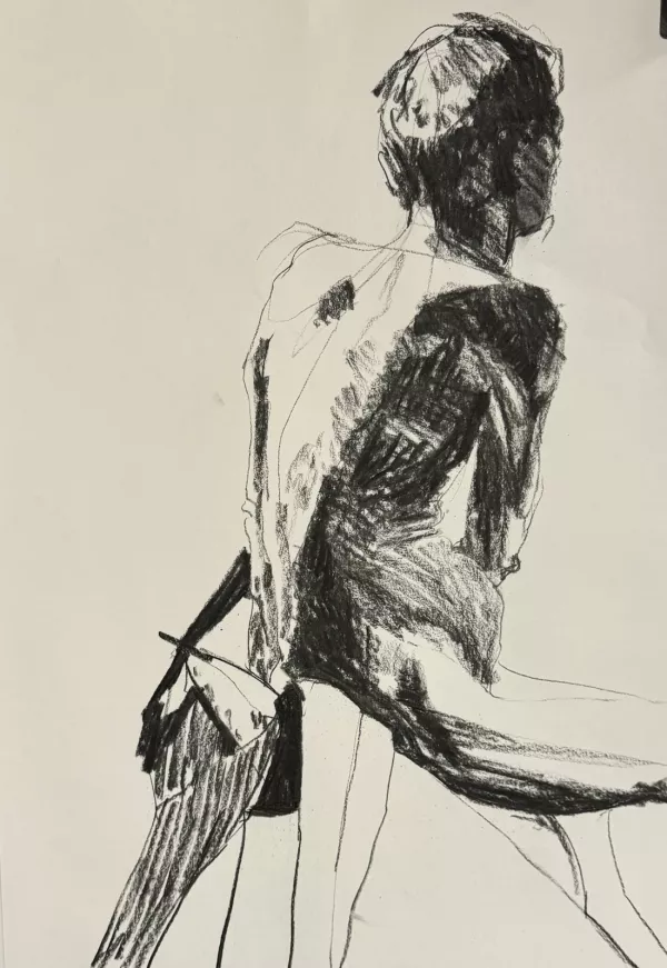 A charcoal study of the back view of a male life model, showing shadow on one side of his body and light on the other side