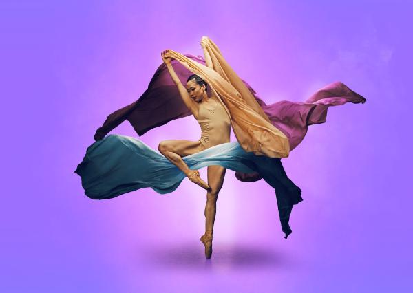 A dance en pointe is surrounded by three pieces of colourful fabric