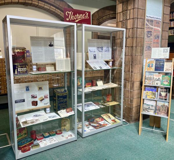 Colour photograph showing display cabinets in a traditional library setting