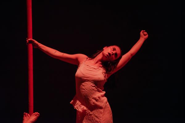 A dancer is lit in red