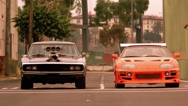 A black and an red car line up for a drag race