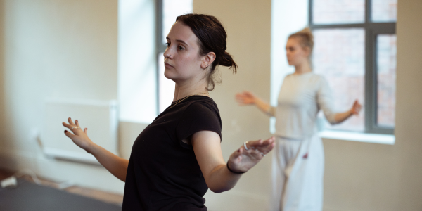 Two dancers with their arms out