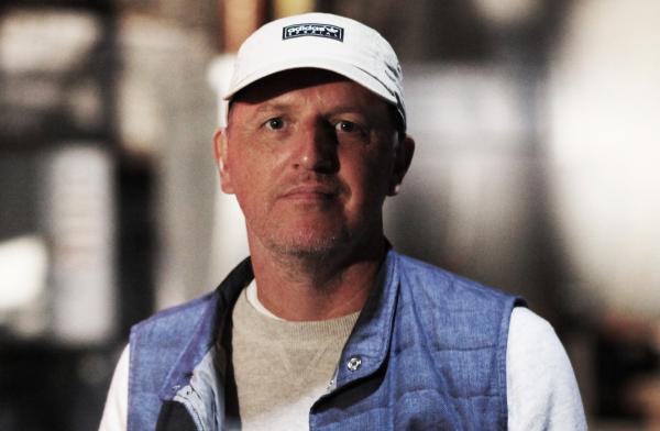 Image of Gary Aspden, a white man wearing a white baseball hat, a long sleeved white top and a blue gilet