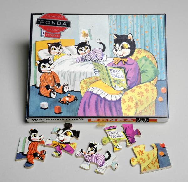 A jigsaw puzzle with an anthropomorphic family of cats. The mother cat is reading to three kittens in their bedroom.