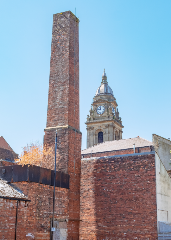 A photograph of Morley Town Hall clock behind a chimney.