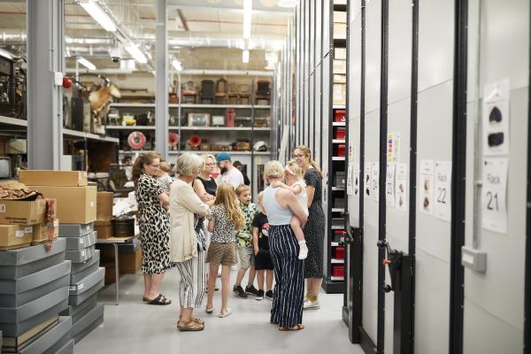 Families standing in a collections store.
