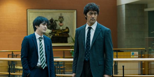 Two men in suits looking in the same direction