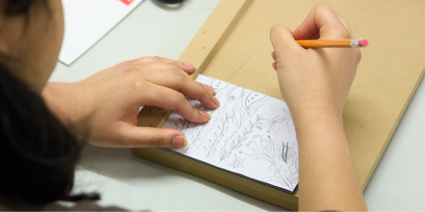 Woman drawing sketch to be carved, line picture with pencil