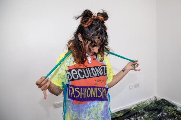 Women with curly brown hair in a DIY tshirt that says Deconize Fashion on it