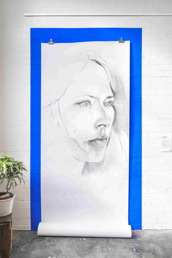 huge drawing of a woman's face on bright blue wall