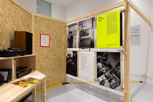 Walls constructed of chipboard and wood, with exhibition panels in yellow and white with black and white photographs
