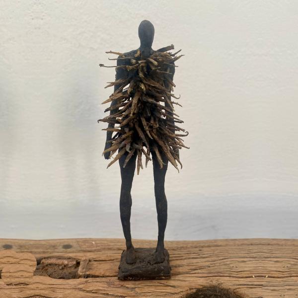 A human-like figure pierced by spikes