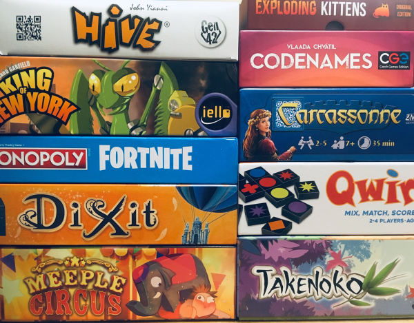 Two stacks of board games, including Dixit, Carcasonne and Meeple Circus.