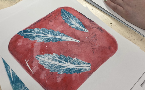 A gelli printed image of some leaves in blue and red