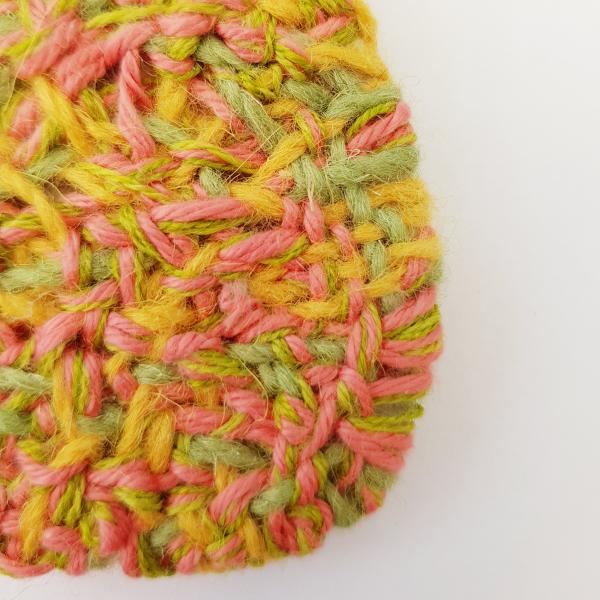 Image shows a section of an abstract woven structure in pink, yellow and green.