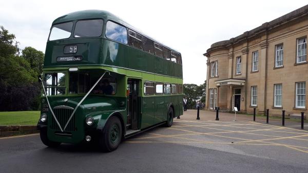 A photograph of a green vintage bus