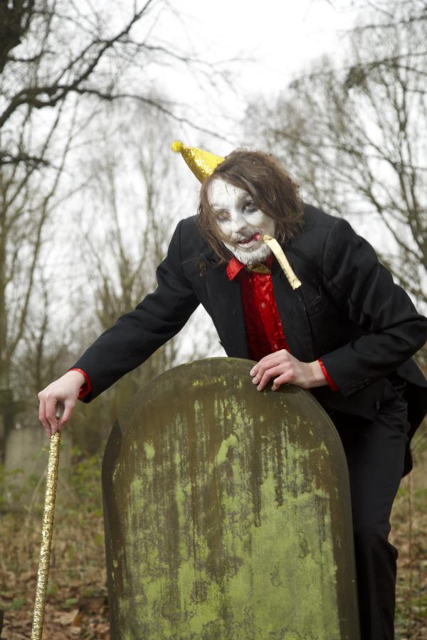 Frankie Monroe standing over a gravestone