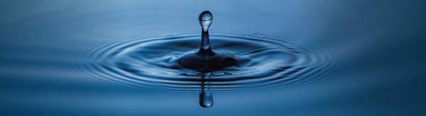 Big water drop over blue water