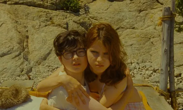 Sam and Suzy hug, and look out past the camera